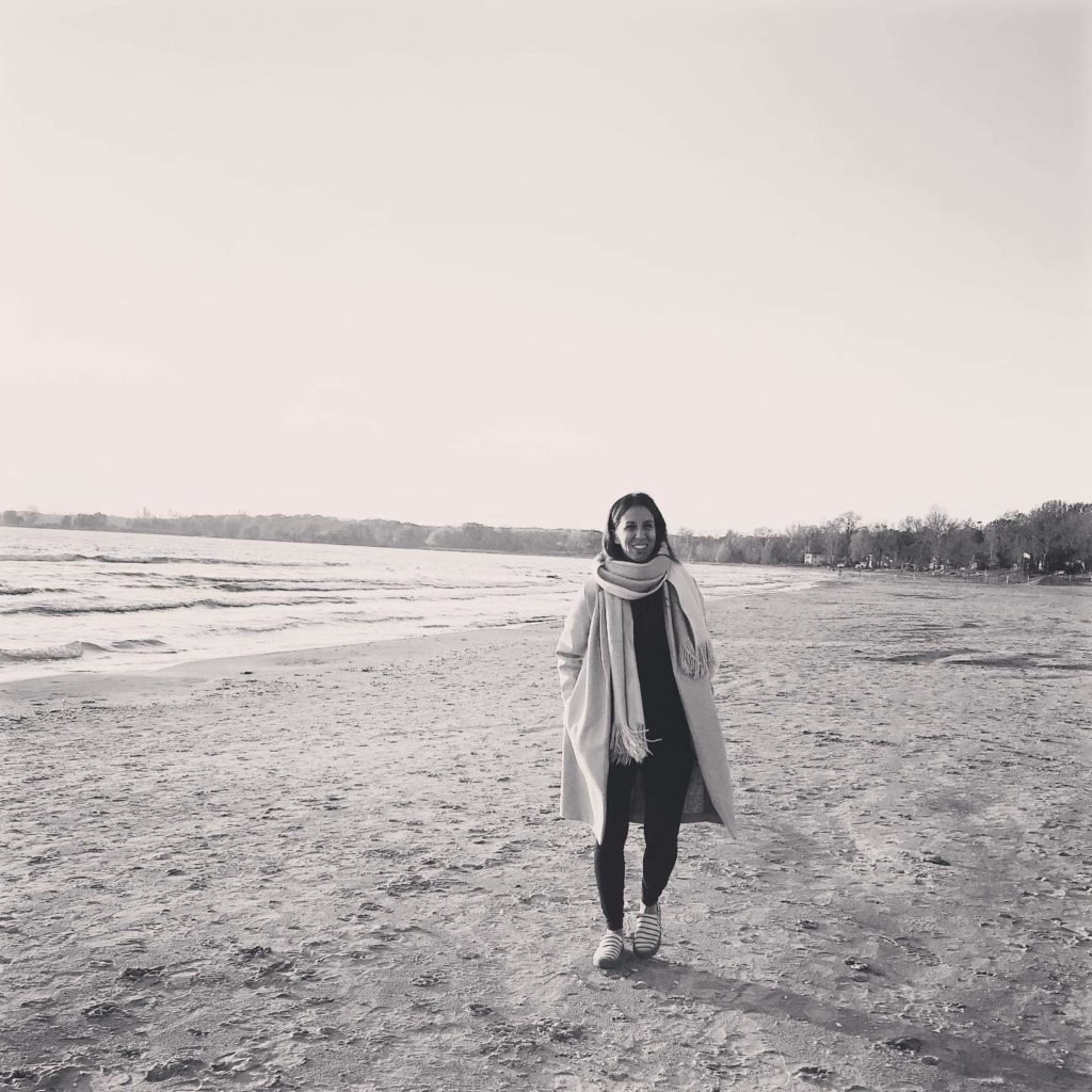 Image of Melaina Gasbarrino walking along the shore